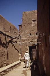 Image du Maroc Professionnelle de  Un berger berbère traverse une rue de l'ancienne Kasbah de Ouarzazate avec son troupeau de chèvres et de moutons, Vendredi 22 Août 1997. De nombreux habitants résident avec leurs animaux au milieu de la maison. (Photo / Abdeljalil Bounhar)